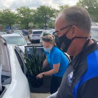 KC Christopher and Dave Huizen help a family unload their car